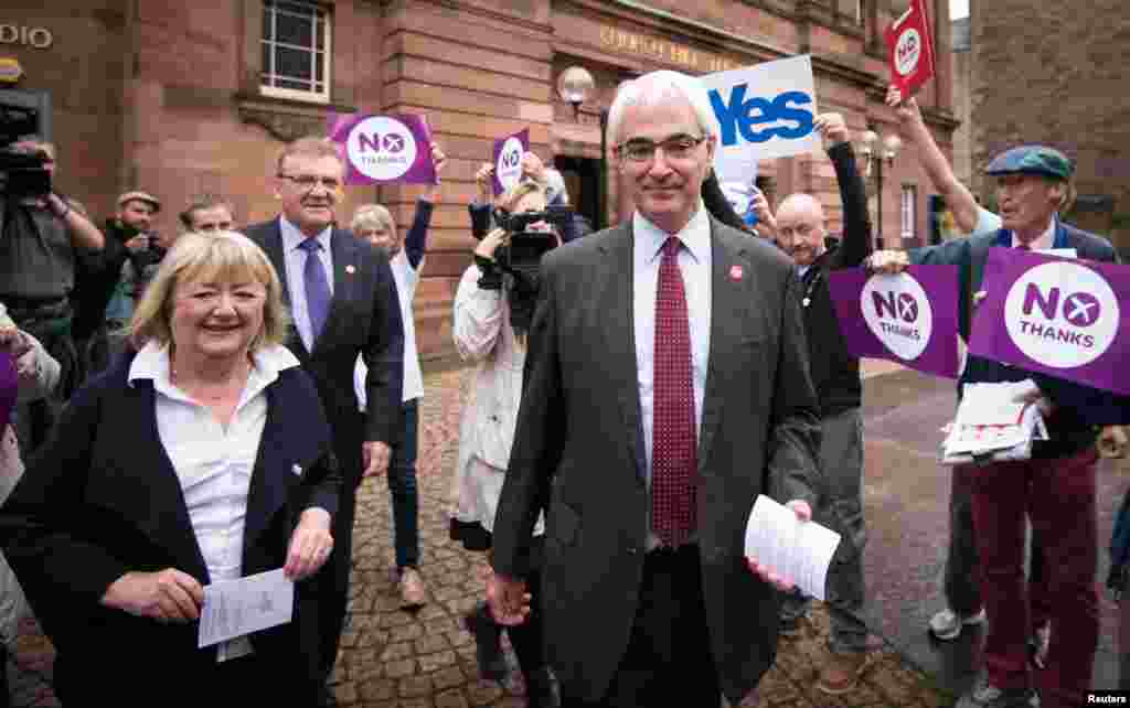 Mantan Kanselir Exchequer dan pemimpin kampanye Better Together, Alistair Darling, bersama istrinya Maggie di luar tempat pemungutan suara di&nbsp;Church Hill Theatre di Edinburgh, Skotlandia (18/9).&nbsp;(Reuters/Stefan Rousseau) 