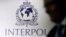 FILE PHOTO: A man passes an Interpol logo during the handing over ceremony of the new premises for Interpol's Global Complex for Innovation in Singapore