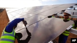 资料照片：南非沿海地区的工人正在安装太阳能电池板(2016年3月29日）