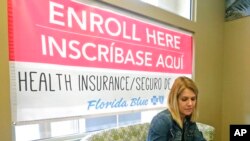 FILE - Catherine Reviati reviews the different Affordable Care Act enrollment options, Nov. 2, 2017, in Hialeah, Fla.
