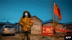 This photo taken on April 21, 2020 shows a staff member keeping watch at a checkpoint in the border city of Suifenhe, in China's northeastern Heilongjiang province. - A cluster of COVID-19 coronavirus cases in China's northeastern city of Harbin has…