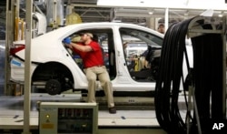 Technicians work on a Toyota Corolla assembly line, Blue Springs, Mississippi, Feb. 12, 2015.