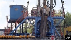 A crew works on a gas-drilling rig at a well site for shale-based natural gas in Zelienople, Pa., June 25, 2012.