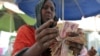 FILE - A money changer counts local currency notes at a local bureau where $100 US dollar exchanges for 750,000 Somaliland shillings in Hargeysa.