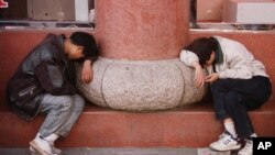 Two Chinese men take a lunch-time rest in the old part of Shanghai, Sunday Nov. 16, 1997. (AP Photo/Paola Vanzo)