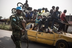 FILE - A Rwandan peacekeeper from the United Nations Multidimensional Integrated Stabilization Mission in the Central African Republic (MINUSCA) patrols the road leading to Damara, Jan. 23, 2021.