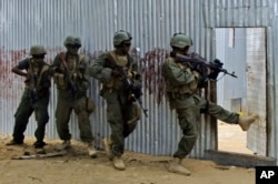 FILE - Somali soldiers search through homes for al-Shabab fighters, during an operation in Ealsha Biyaha, Somalia, June, 2, 2012.