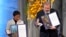 Nobel Peace Prize winners Dmitry Muratov from Russia and Maria Ressa of the Philippines pose with their awards during the Nobel Peace Prize ceremony at Oslo City Hall, Norway, Dec. 10, 2021.
