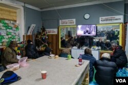 2023年1月20日，在炮弹纷飞之际，当地居民在巴赫穆特的 一处地堡观看电视。(美国之音博夏特拍摄)