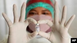 Seorang petugas medis menunjukkan sebotol vaksin Pfizer COVID-19 saat kampanye vaksinasi dosis ketiga di Rumah Sakit Umum Daerah Tangerang Selatan di Tangerang, Rabu, 12 Januari 2022. (Foto: AP)