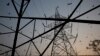 FILE - Birds fly around electric power towers, outskirts of New Delhi, March 1, 2016.