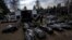 Cemetery workers unload bodies of killed civilians from a van in a cemetery in Bucha, on the outskirts of Kyiv, Ukraine, April 7, 2022.