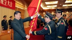 中共领导人习近平在北京举行的中国人民解放军战区成立大会上向火箭军将领、中国防长魏凤和（中）授予军旗。（2015年12月31日）