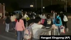 富士康在河南郑州的苹果代工厂工人因新冠病毒疫情逃出被封的厂区。（美联社2022年10月29日）