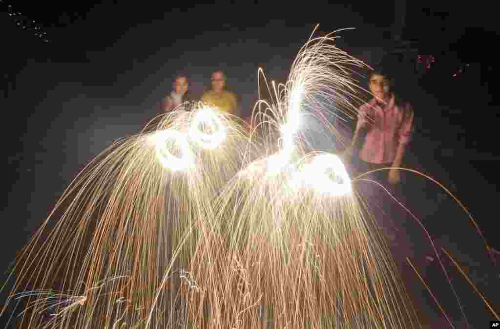 Para warga menyalakan kembang api untuk merayakan Diwali di Jammu, India (3/11). (AP/Channi Anand)