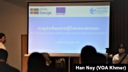 អ្នកចូលរួម​កំពុង​មើល​ផ្ទាំង​នៃ​ការស្ទង់មតិ​នៅ​រាជធានី​ភ្នំពេញ​នៅ​ថ្ងៃទី៣១ ខែតុលា ឆ្នាំ២០២២។ (ហាន ណូយ/វីអូអេ)