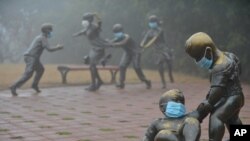 2017年1月4日，河南濮阳，在雾霾里，街头雕塑也被戴上口罩