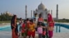 A group of Indians who visited the Taj Mahal monument that was Wednesday reopened to public after the lockdown to curb the spread of coronavirus gather to get photographed in Agra, India, June 16, 2021.