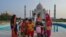 A group of Indians who visited the Taj Mahal monument that was Wednesday reopened to public after the lockdown to curb the spread of coronavirus gather to get photographed in Agra, India, June 16, 2021.