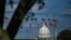 FILE - The dome of the U.S. Capitol building is seen behind a row of U.S. flags in Washington, April 10, 2020.