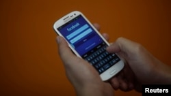 一个智能手机用户在登录脸书账户（资料照片）