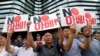 South Korean protesters hold up cards during a rally against Japan in front of a building that houses the Japanese embassy in Seoul, South Korea, Aug. 2, 2019. The signs read " Japanese Prime Minister Shinzo Abe."