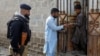 A worker from the National Database and Registration Authority, along with a police officer, verifies the identity cards of an Afghan citizen during a door-to-door search for undocumented Afghan nationals in Afghan Camp on the outskirts of Karachi, Pakistan, on Nov. 21, 2023.