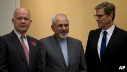 British Foreign Secretary William Hague, left, Iranian Foreign Minister Mohammad Javad Zarif and Germany's Foreign Minister Guido Westerwelle, right, gather for the third day of closed-door nuclear talks at the Intercontinental Hotel in Geneva Switzerland