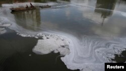 浙江嘉兴的一条河遭到污染，工人们在清理这条河