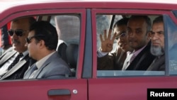 穆斯林兄弟会及被推翻的总统穆尔西的律师乘车抵达审判现场并打出手势。（2013年11月4日）
