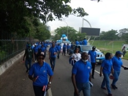 Josiah Emerole (Middle) Public Enlightenment officer at NAPTIP walking with other participants during the Abuja awareness march, July 29, 2021. (Timothy Obiezu/VOA)