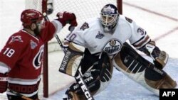 **CORRECTS BYLINE**Carolina Hurricanes' Mark Recchi (18) knocks down the puck as Edmonton Oilers goaltender Jussi Markkanen, of Finland, watches in the second period during Game 2 of the Stanley Cup hockey finals Wednesday, June 7, 2006 in Raleigh, N.C. (