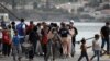 FILE - Refugees and migrants from the destroyed Moria camp wait to board a ferry that will transfer them to the mainland, at the port of Mytilene on the island of Lesbos, Greece, Sept. 28, 2020. 