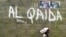 A girl walks past a wall with graffiti about the al-Qaida network in a Muslim area of the northern city of Kano, Nigeria, (File photo).