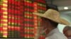 An investor looks at an electric board showing stock information at a brokerage house in Haikou, Hainan province, China, Aug. 11, 2015. 
