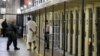 FILE - An inmate is led out of his cell at San Quentin State Prison in San Quentin, California, Aug. 16, 2016. A group of 114 Iraqis held in detention in the U.S. and due to be deported argue that their forcible repatriation and threats they would face in their homeland would run counter an international treaty against torture.