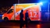 Police officers walk next to an emergency vehicle after a stabbing at the Holocaust memorial in Berlin, Germany, Feb. 21, 2025.
