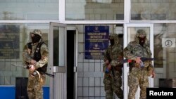 مردان مسلح روس گرا در برابر ساختمان اشغالی شورای شهر کوستیانتینیوکا پاس می دهند - ۲۸ آوریل 