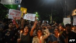 ແພດ​ໝໍ ແລະ ນັກ​ເຄື່ອນ​ໄຫວ​ຖື​ປ້າຍ ແລະ ທຸງ​ຊາດ ອິນ​ເດຍ ໃນ​ຂະ​ນະ​ທີ່​ເຂົາ​ເຈົ້າ​ເຂົ້າ​ຮ່ວມ​ການ​ປະ​ທ້ວງ ເພື່ອ​ປະ​ນາມ​ການ​ຂົ່ມ​ຂືນ ແລະ ຂ້າ​ແພດ​ໄວ​ໜຸ່ມ​ຄົນ​ນຶ່ງ, ໃນ​ເມືອງ ຄອ​ລ​ຄາ​ຕ້າ, 14 ສິງ​ຫາ 2024.