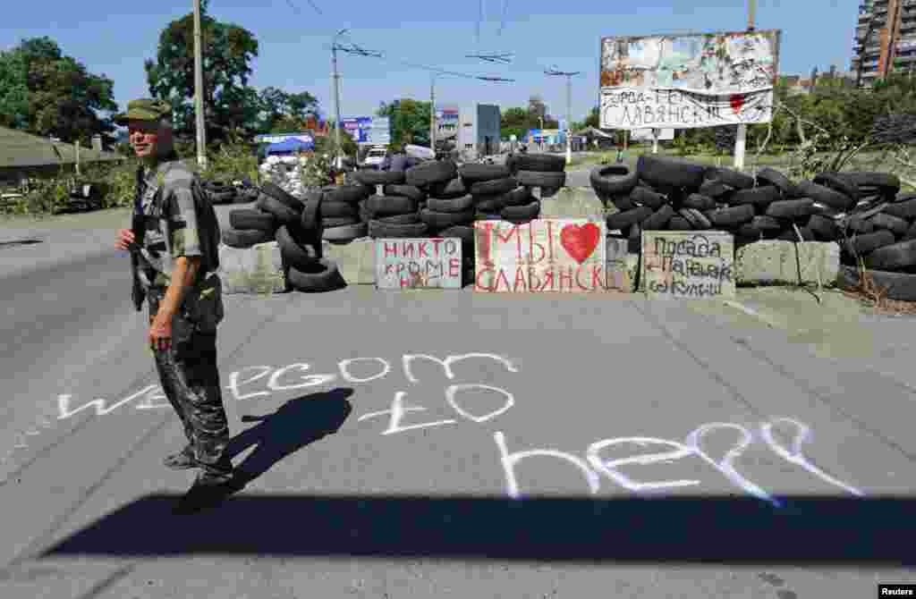 Seorang tentara separatis bersenjata pro-Rusia berjaga di sebuah pos penjagaan di Slovyansk, Ukraina Timur (1/7).
