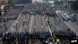 在香港警察施放催泪瓦斯后，抗议者在政府总部外与警方对峙。(2019年6月12日)