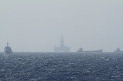 FILE - Ships and an oil rig, center, which China calls Haiyang Shiyou 981, and Vietnam refers to as Hai Duong 981, is seen in the South China Sea, off the shore of Vietnam, May 14, 2014.