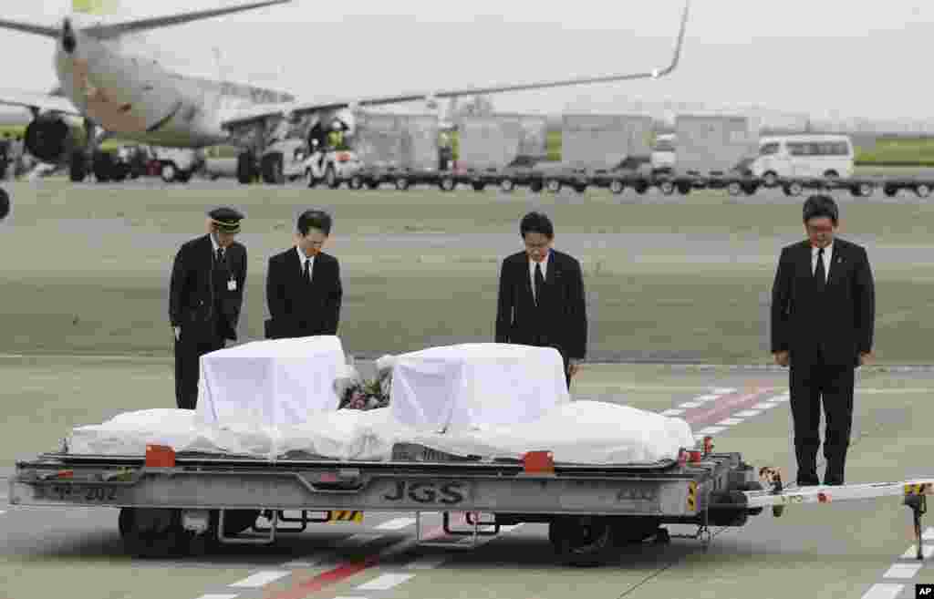 Japanese Foreign Minister Fumio Kishida, second right, bows in front of the coffins of victims in a weekend attack on a restaurant in Bangladesh, at Haneda Airport in Tokyo as the bodies are returned. Seven Japanese citizens were killed in the attack.