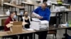 FILE - Election workers scan ballots during a recount of the presidential vote, at the Georgia World Congress Center, in Atlanta, Georgia, Nov. 25, 2020.