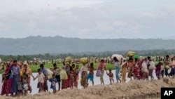 ​ຊາວ​ມຸ​ສ​ລິມ ໂຣ​ຮິງ​ຢາ, ຜູ້​ທີ່​ໃຊ້​ເວ​ລາ​ສີ່​ວັນ​ຢູ່​ກ່ງ​ແຈ້ງຫຼັງ​ຈາກ​ຂ້າ​ເຂດ​ຊາຍ​ແດນ​ຈາກ​ມຽນ​ມາ ເຂົ້າ​ໄປ​ໃນ ບັງ​ກ​ລາ​ແດັ​ສ, ຫາມ​ເຄື່ອງ​ຂອງ​ຂອງ​ເຂົາ​ເຈົ້າ ຫຼັງ​ຈາກ​ໄດ້​ຮັບ​ອະ​ນຸ​ຍາດ​ໃຫ້​ເຂົ້າ​ໄປ​ຫາ​ສູນ​ອົບ​ພະ​ຍົບ, ຢູ່​ເມືອງ ປາ​ລົງ ຄາ​ລີ, ປະ​ເທດ ບັງ​ກ​ລາ​ແດັ​ສ, 19 ຕຸ​ລາ 2017.