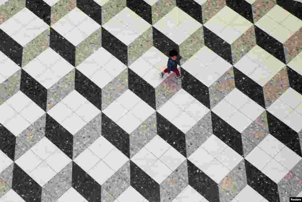 ក្មេង​ប្រុស​ម្នាក់​កំពុង​ដើរ​នៅ​ក្នុង​ផ្សារទំនើប​ក្នុង​ទីក្រុង​តូក្យូ​ប្រទេស​ជប៉ុន។