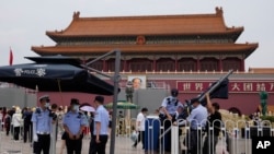 警察在北京天安门广场为执勤岗位架设遮阳伞。(2021年6月23日)