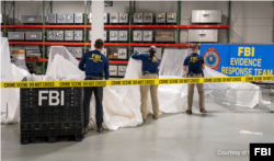 美国联邦调查局提供的图片显示调查局特工在检验美国海军在南卡罗莱纳州海岸外打捞出来的被击落的中国间谍气球碎片。（2023年2月7日）