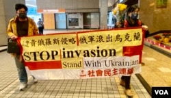 社民连主席陈宝莹及成员余炜彬游行到俄罗斯驻港领事馆所在的新鸿基中心外抗议 (美国之音/汤惠芸)