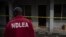 FILE - A National Drug and Law Enforcement Agency (NDLEA) official searches for evidence of illegal substances in Obinugwu village in southeast Nigeria, Nov. 22, 2018.